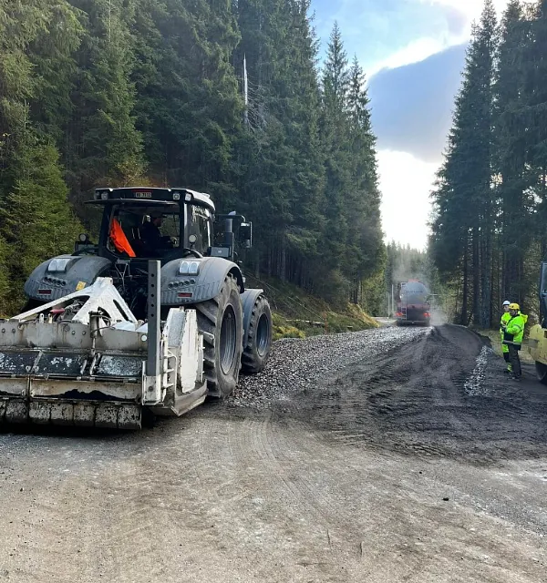 Traktor og lastebil i skogterreng