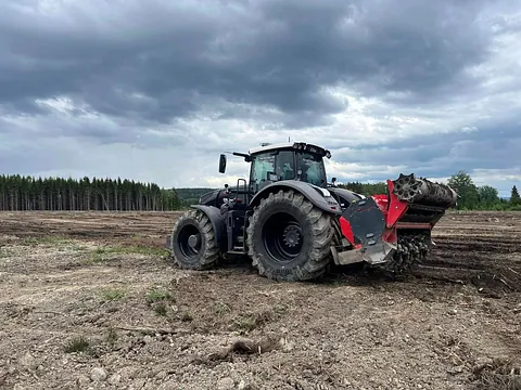 Rød gravemaskin på jorde